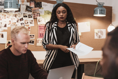 The image depicts people of different color at a workplace